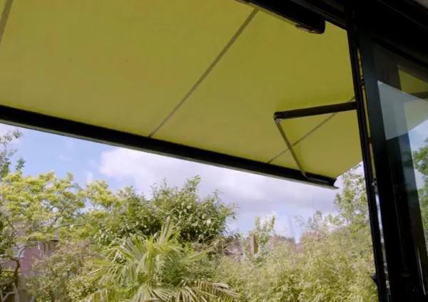 Close up of underside of a moss green awning partially extended.