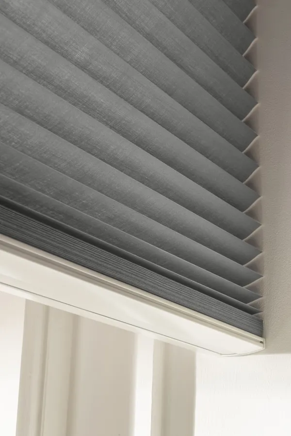 Close up of a mink brown duette blind partially raised.