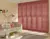 Living room in pale corn yellow with tall window dressed in full height shutters in salmon with sofa in pale peach with contrasting peach and salmon cushions.