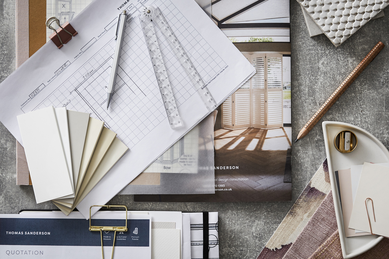 quotation papers, window sketches and stationery scattered on a table