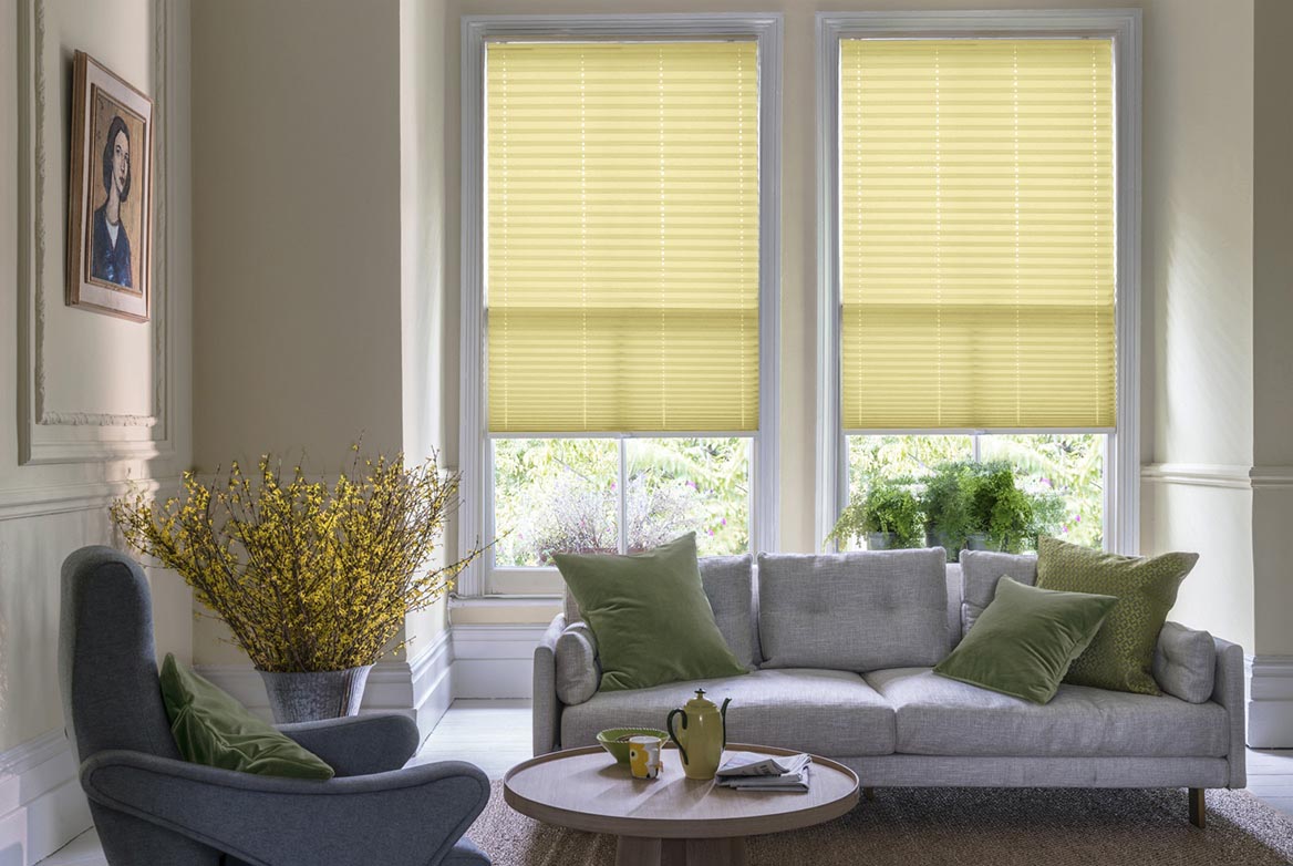 yellow Pleated blinds have been fitted to multiple windows in a luxuriously styled kitchen in marble and white. California Sunshine has a plain style that complements the room.