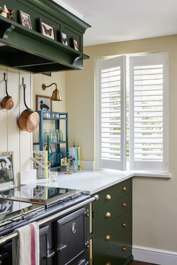 white vinyl shutters slightly open in kitchen window