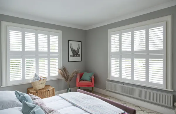white vinyl shutters in two bedroom windows on adjacent walls 