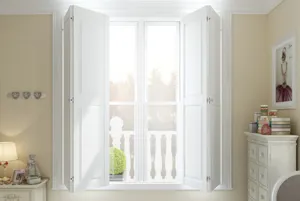 Cream bedroom with white furniture and a window dressed in white solid shutters, partially folded back.