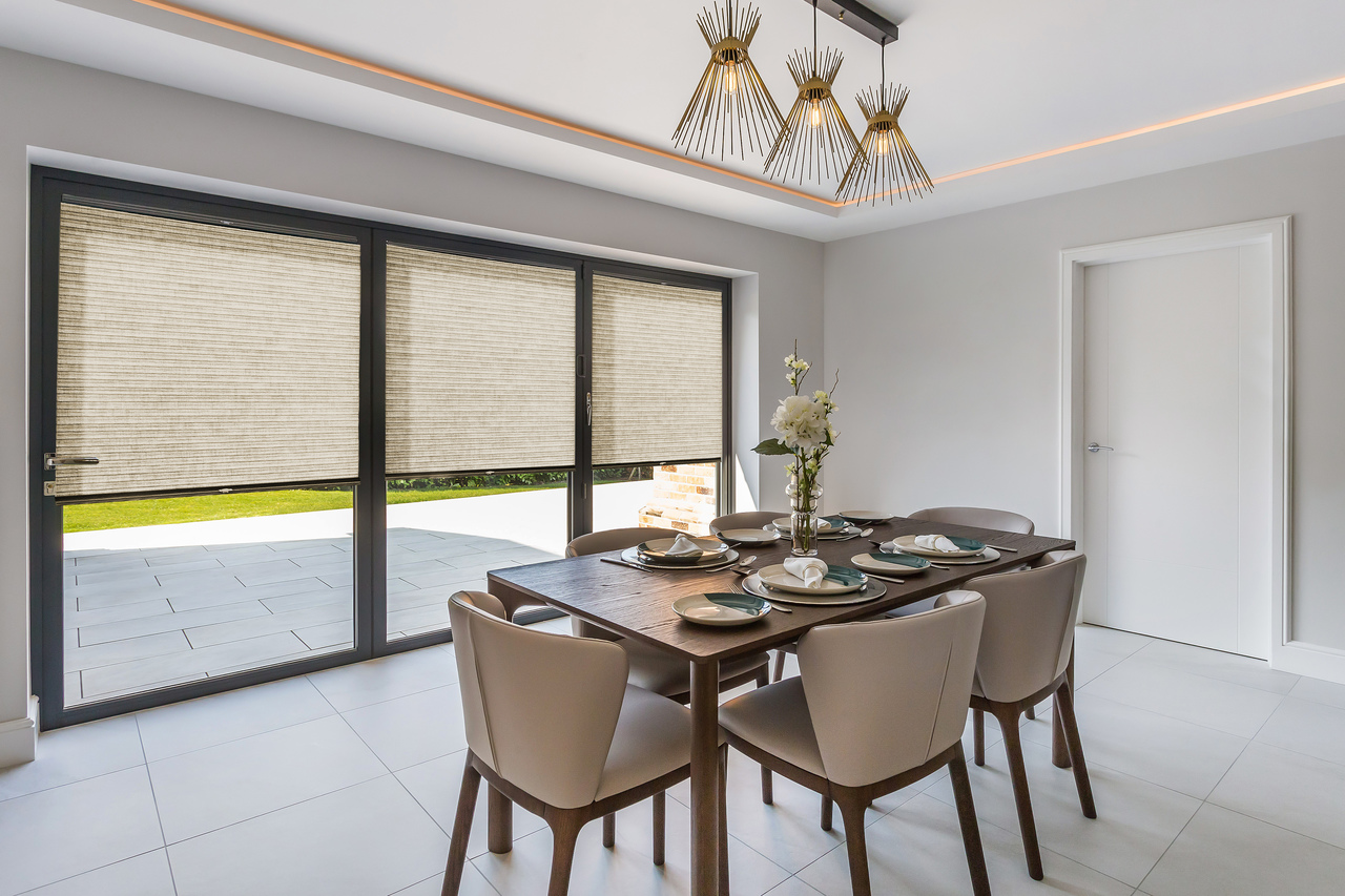 Scandia Hus Naturelle Stone Ochre Duette Pleated blind fitted to multiple door windows in a dining room