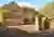Large Yorkshire-style stone house and drive with integral garage door in mid brown matching front door, with climbing plant above garage.