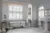 White bathroom with bath under rectangular window dressed in white shutters, and arched window on left wall also in white shutters.