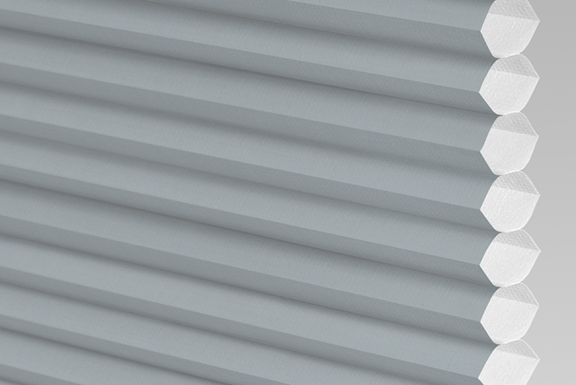 Close up of a pale grey micro hive honeycomb blind.