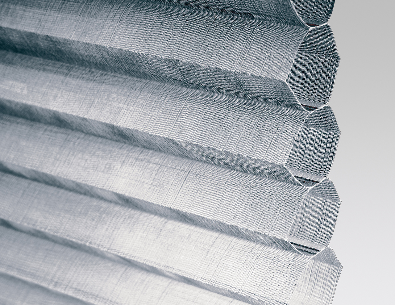 Close up of a steel grey duette blind showing the honeycomb shape at the side.