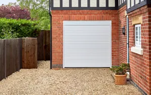 Red brick and Tudor style house with integrated garage at abutting corner with a white garage door.