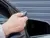 A person opening a garage door with an electric key fob from their car.